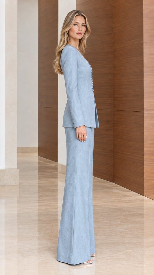 Side profile view of women's light blue tailored two-piece pant suit