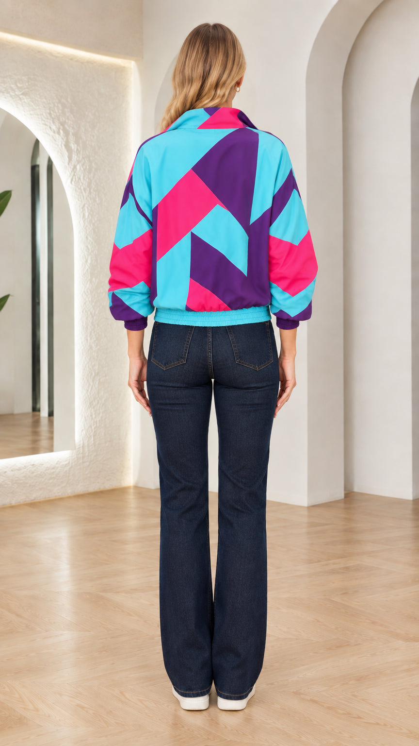 Back view of woman wearing turquoise and purple geometric windbreaker jacket