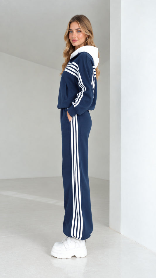 Side profile view of woman wearing navy blue striped hooded sweatsuit set